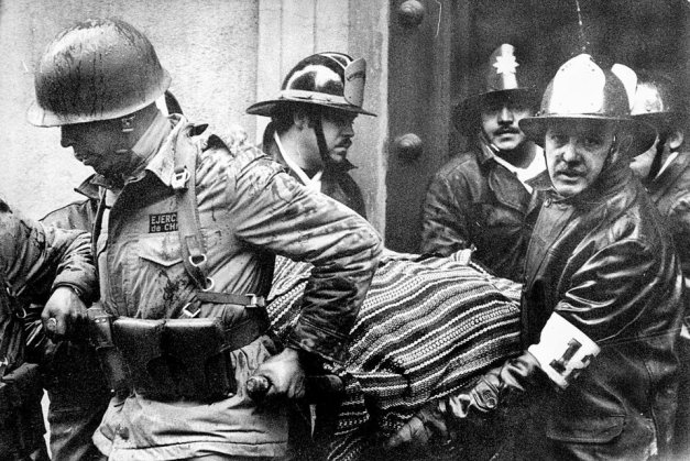 Στρατιώτες και πυροσβέστες μεταφέρουν το σώμα του Αουγκούστο Πινοσέτ, μετά τον βοβμβαρδισμό του προεδρικού μεγάρου, στο πραξικόπημα της 11/9.1973 από τον Πινοσέτ 